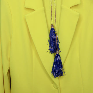 Collar largo con borlas de plumas azules y detalles dorados elegantes