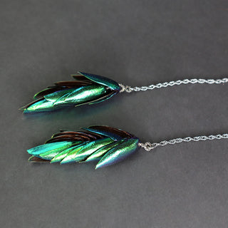 Corbatero de plumas de mayate con cadena en plata oxidada y detalles pavé.